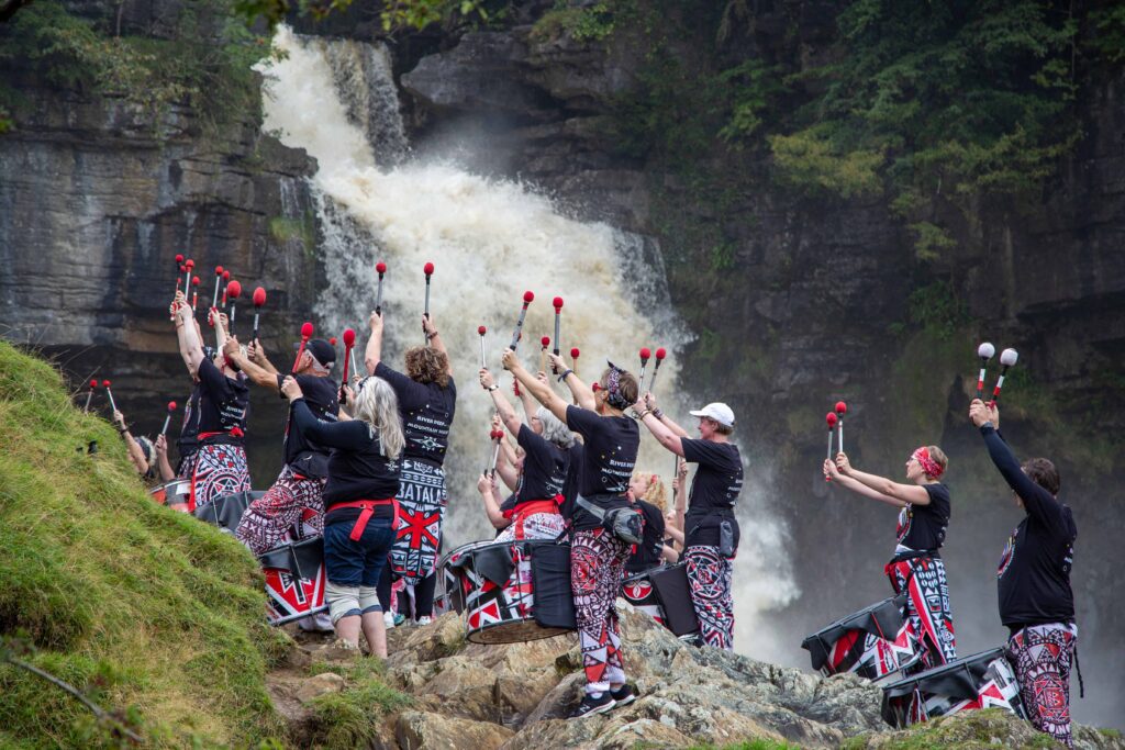 Batala Lancaster drummers in Ingleton waterfall